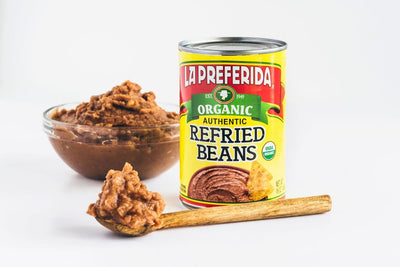 Organic refried beans served in a bowl beside the can, made with no lard and wholesome ingredients.