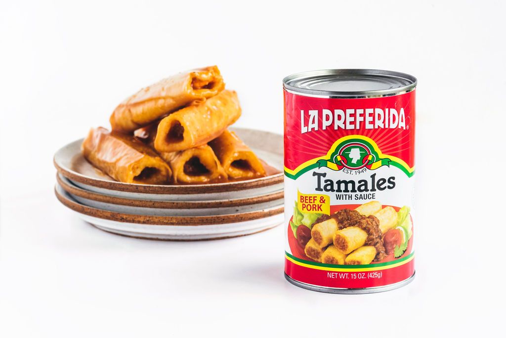Can of La Preferida beef and pork tamales next to a plate of hot tamales